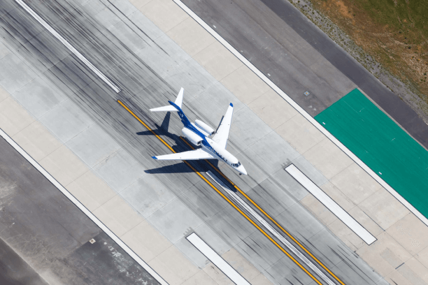 A White and Blue Jet Running on a Runway Top View